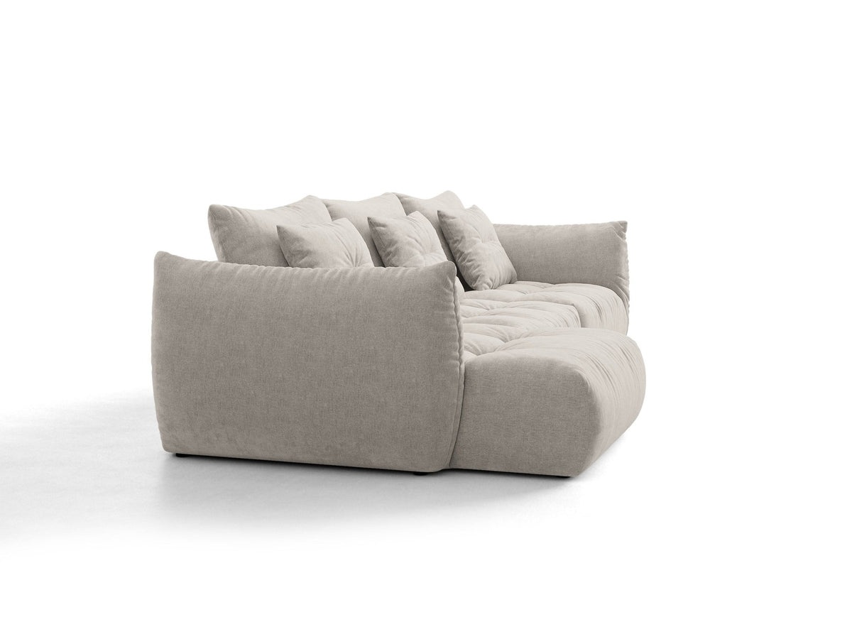 Beiges L-Sofa links von Micadoni mit weichem Veloursstoff Casino, schwarzen Kunststoffbeinen und breiter, tiefer Sitzfläche.