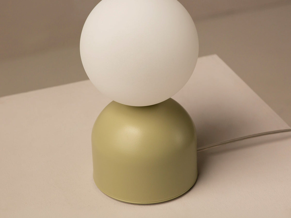 Tischlampe Ely von Micadoni mit rundem Metallfuss und mattem Glasschirm in Beige, Höhe 21 cm, Breite und Tiefe je 12 cm.
