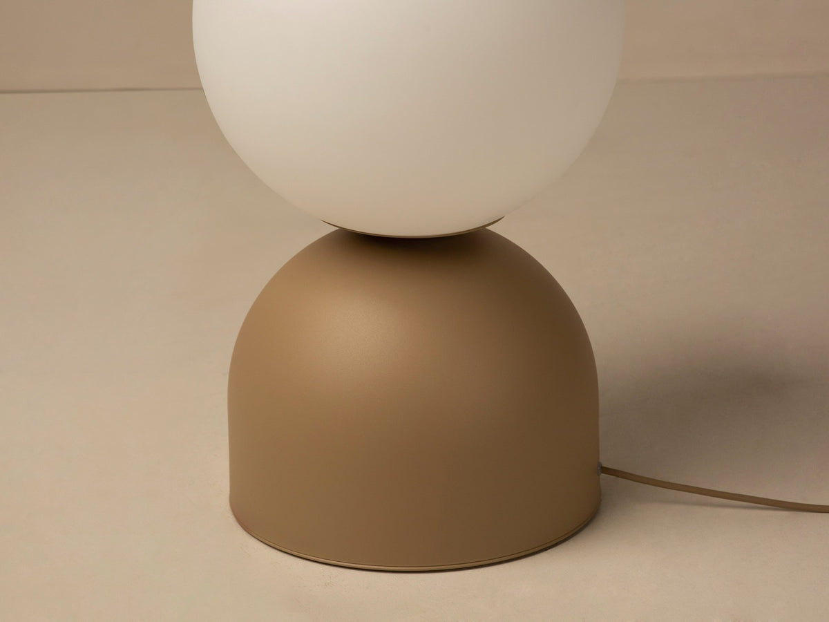 Tischlampe Ely von Micadoni mit rundem Metallfuss und mattem Glasschirm in Beige, Höhe 21 cm, Breite und Tiefe je 12 cm.