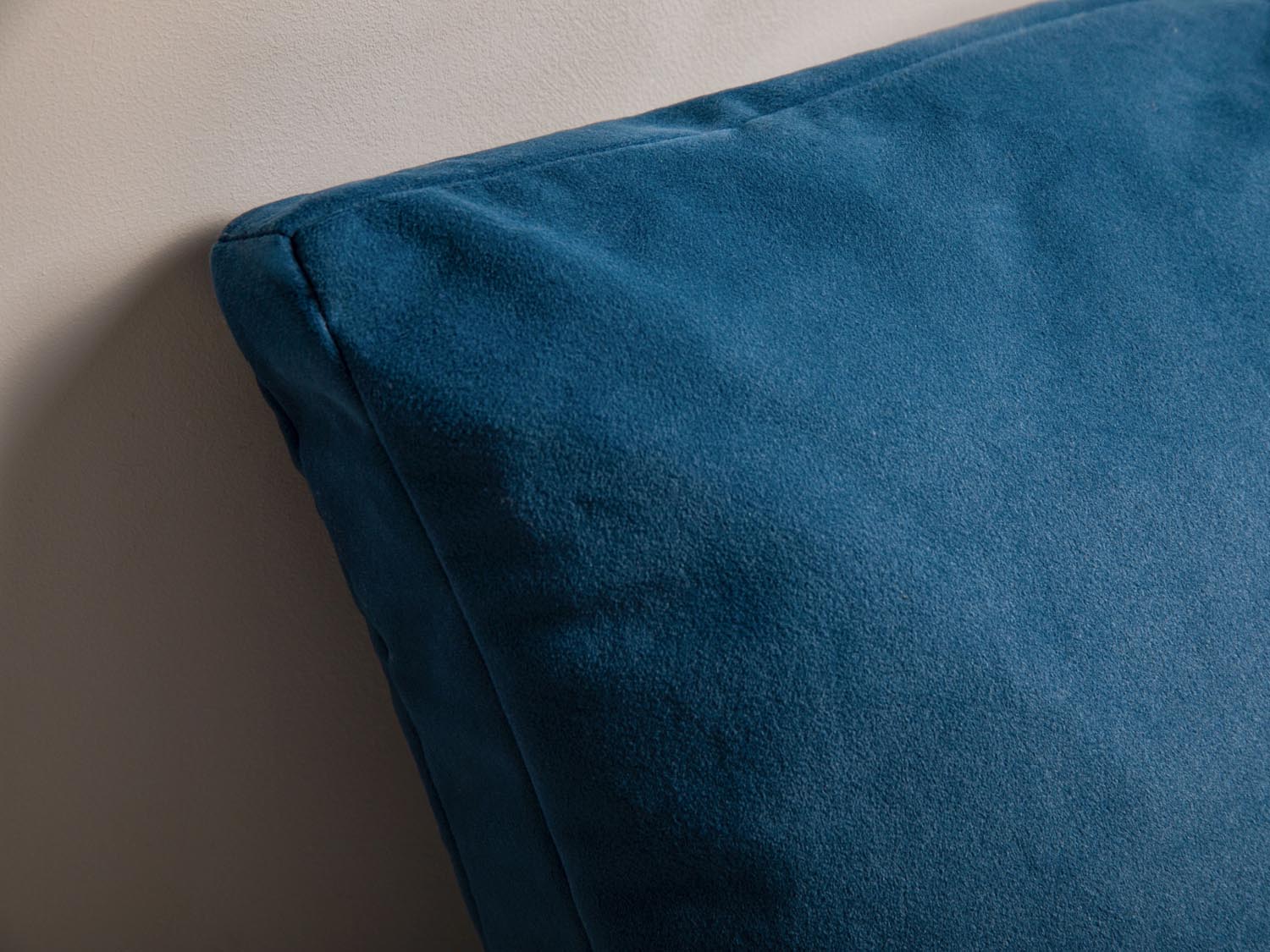 Weiches Velourkissen mit modernen Streifen in harmonischen Blautönen, perfekt für eine stilvolle und einladende Wohnatmosphäre.