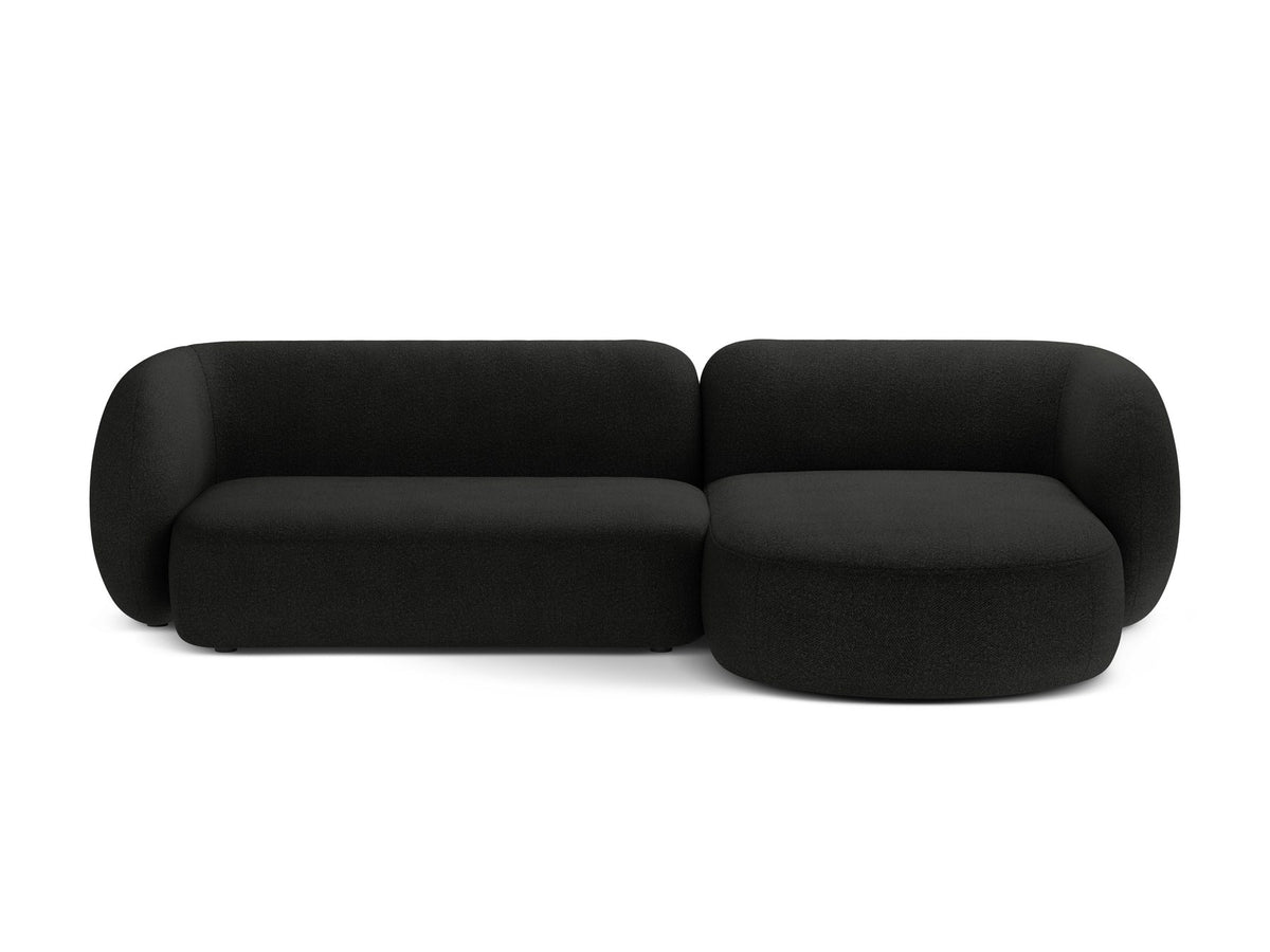Weisses Ecksofa rechts Kate von Micadoni mit strukturiertem Bouclé-Stoff, schwarzen Kunststoffbeinen und niedriger Rückenlehne.
