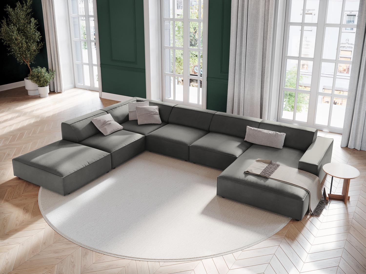 Elegantes, modulares Ecksofa Jodie Velour in sanftem Grau, ideal für stilvolle Wohnräume, präsentiert in einer einladenden Atmosphäre.
