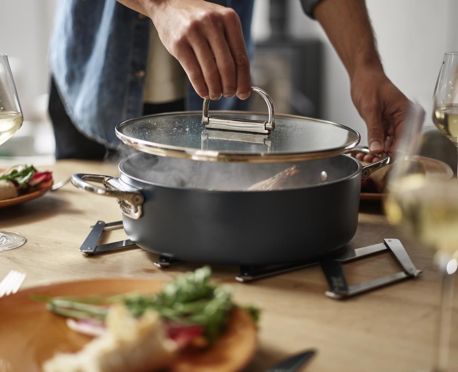 Kompakter Schmortopf mit innovativen klappbaren Griffen, ideal für platzsparendes Verstauen und vielseitiges Kochen.