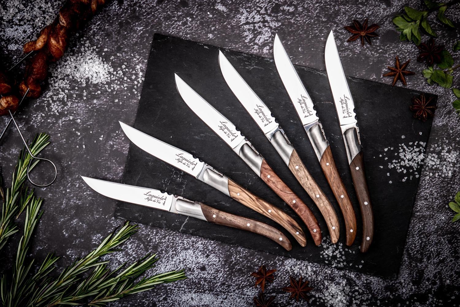 Exquisite Laguiole Steakmesser mit Griffen aus edlen Holzarten, ideal für stilvolles Speisen und gehobene Tischkultur.