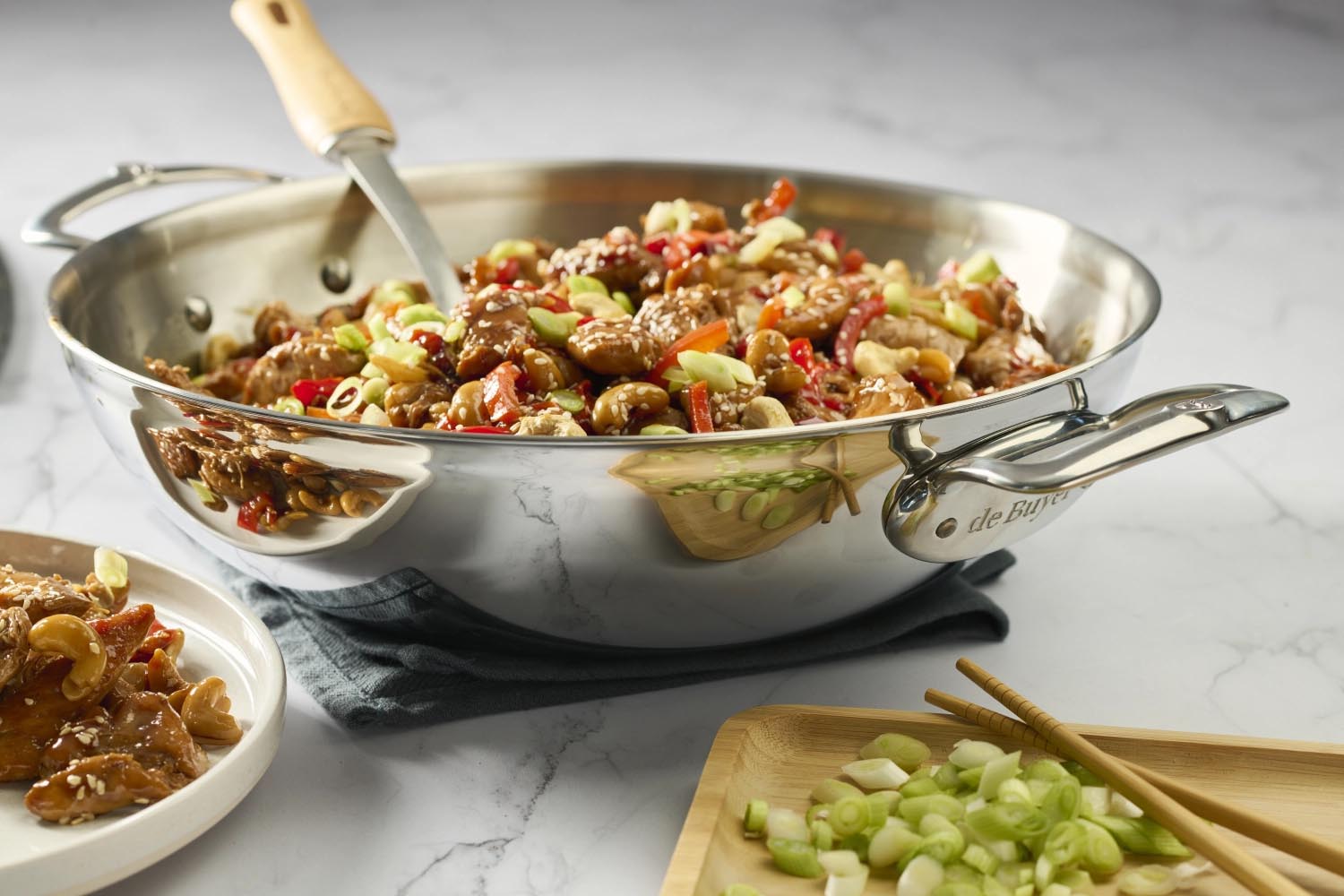 Eleganter Edelstahl-Wok von de Buyer, 32 cm, mit zwei Griffen, perfekt für gleichmäßiges Garen und vielseitige Kochmöglichkeiten.
