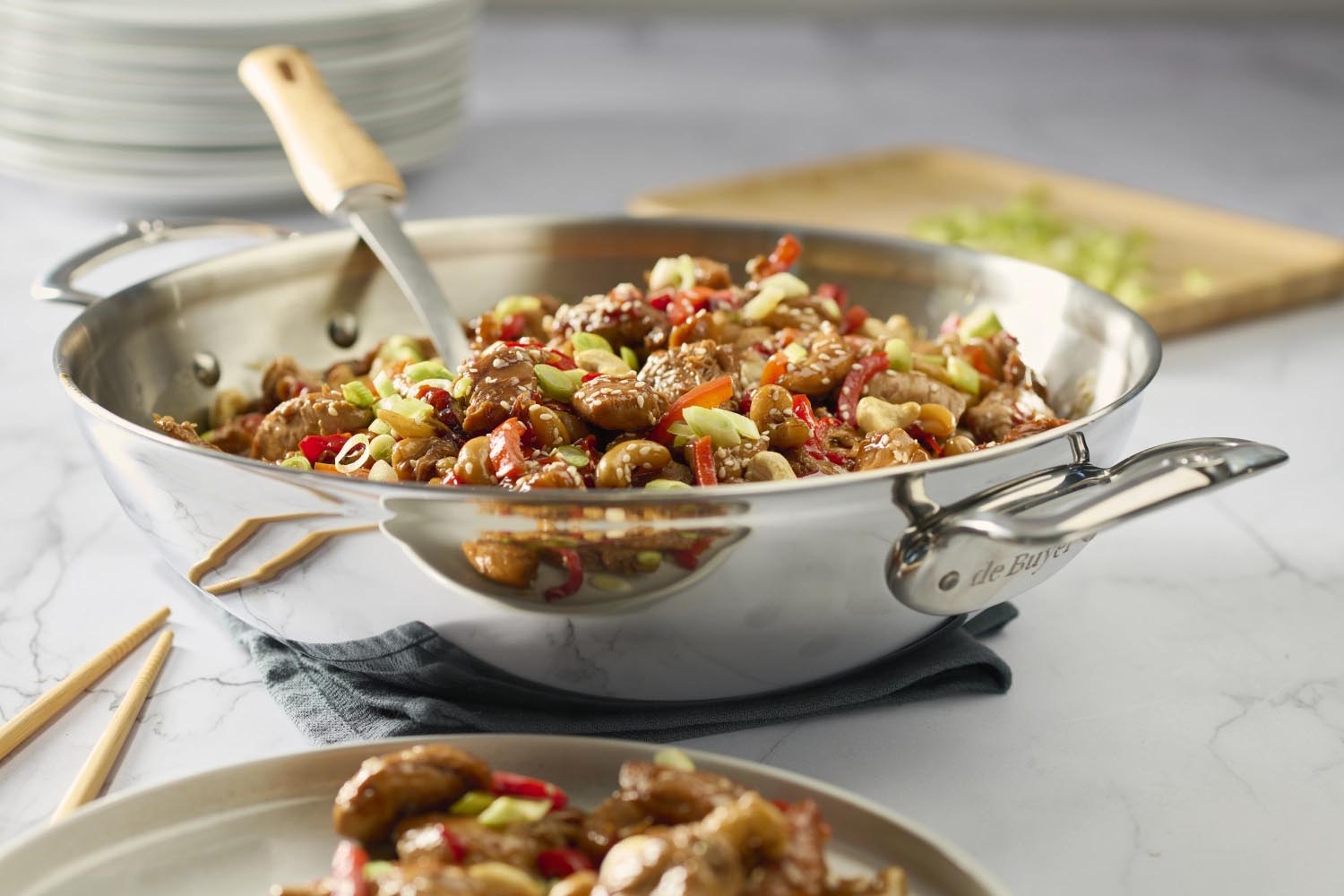 Hochwertiger Edelstahl-Wok von de Buyer, 32 cm, mit zwei Griffen, ideal für gleichmäßiges Kochen und vielseitige Gerichte.