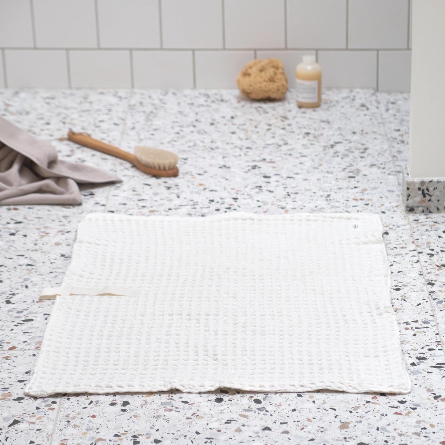 Luxuriöse Badematte aus Bio-Baumwolle, 80x55cm, in natürlichem Weiß. Weiche Waffelstruktur, nachhaltig und stilvoll.