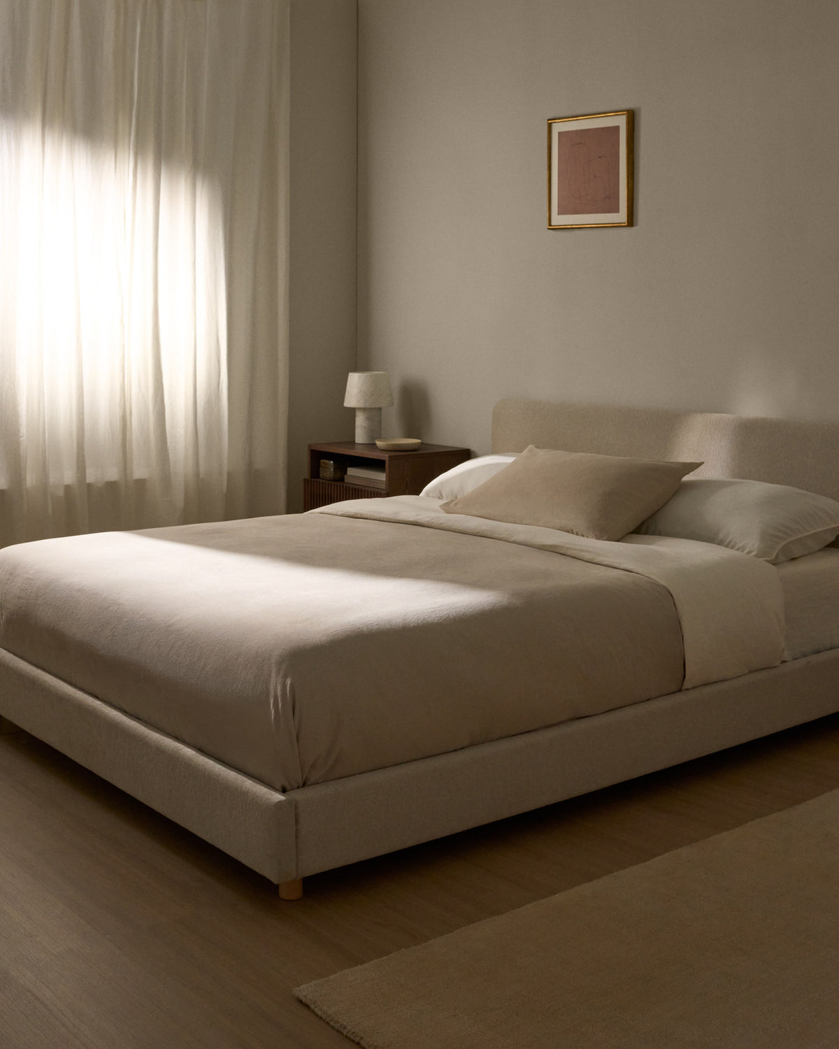 Polsterbett Selven von Kave Home in Beige mit geschwungenem Kopfteil, Chenille-Bezug, Gestell aus Holz und Eisen, Beine aus massivem Buchenholz
