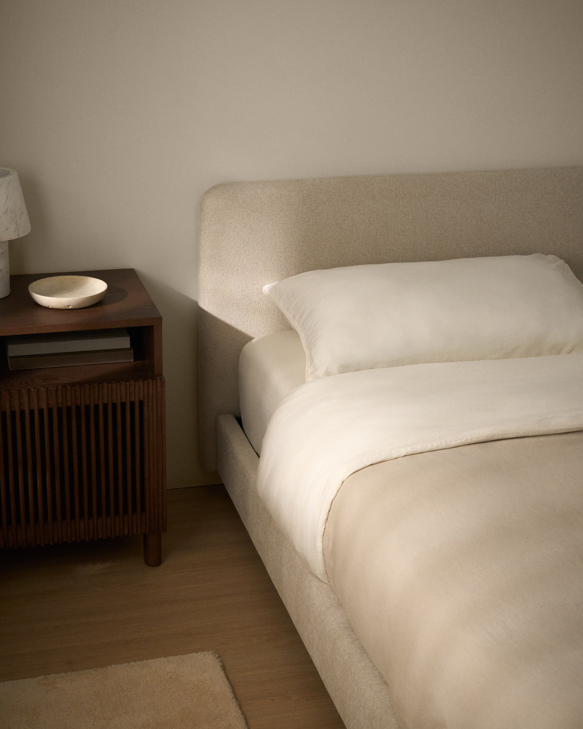 Polsterbett Selven von Kave Home in Beige mit geschwungenem Kopfteil, Chenille-Bezug, Gestell aus Holz und Eisen, Beine aus massivem Buchenholz