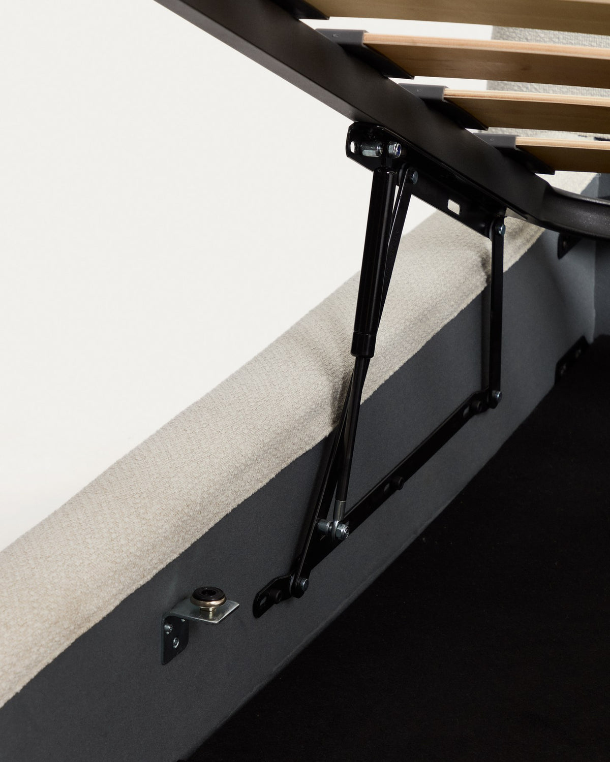 Foto eines Betts mit gepolstertem, geschwungenem Kopfteil aus ecrufarbener Chenille und aufklappbarem Bettkasten für 90x200 Matratzen.