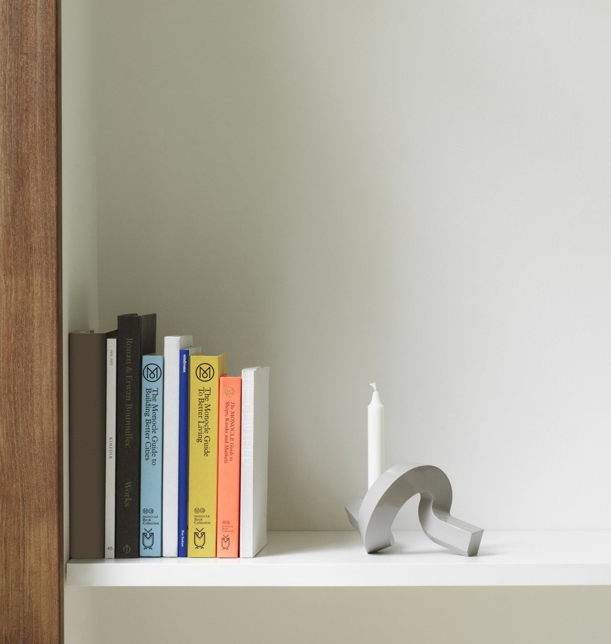 Kerzenhalter Crooked von Normann Copenhagen aus lackiertem Aluminium in Warmes Grau mit geschwungener, skulpturaler Form.