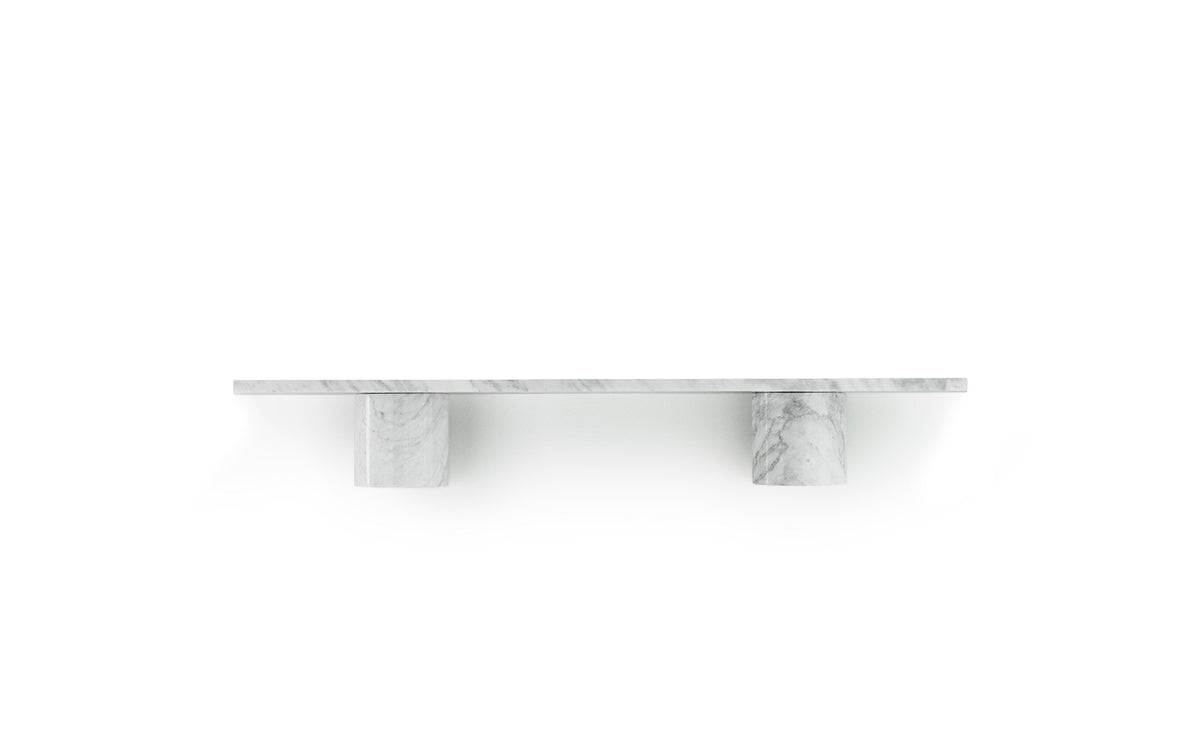 Wandregal Sten 80 cm aus weissem Carrara-Marmor mit einer geraden Steinplatte auf zwei runden, abgerundeten Steinträgern an einer Wand.