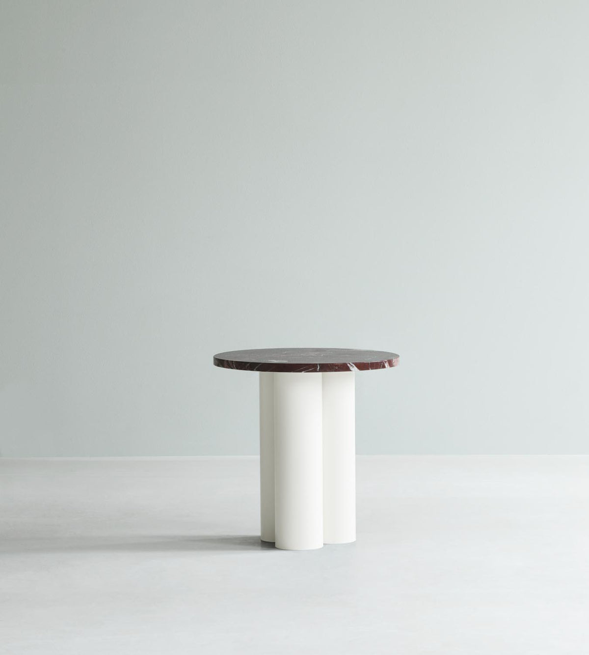 Beistelltisch Dit von Normann Copenhagen mit runder Tischplatte aus Stein in Sand Travertine Light, getragen von drei zylindrischen Stahlbeinen.