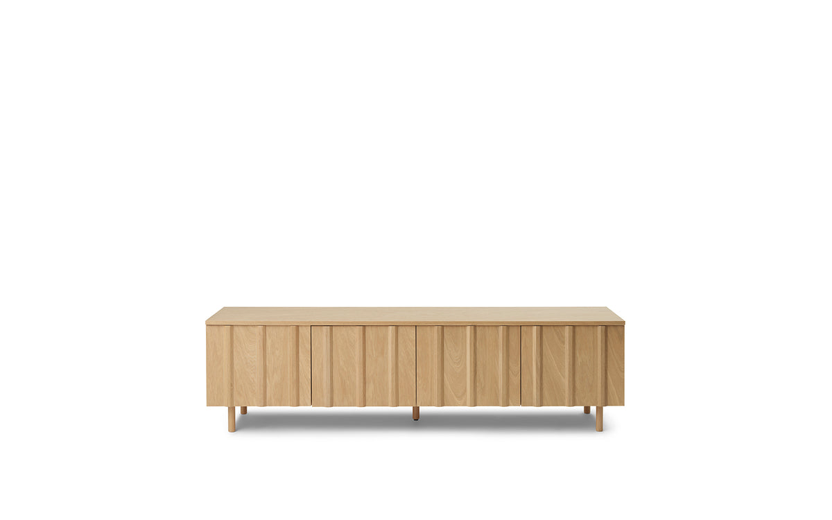 Niedriges Sideboard aus bemaltem und lackiertem Eichenfurnier mit trapezförmigen Lamellen aus massivem Eichenholz, Frontansicht.
