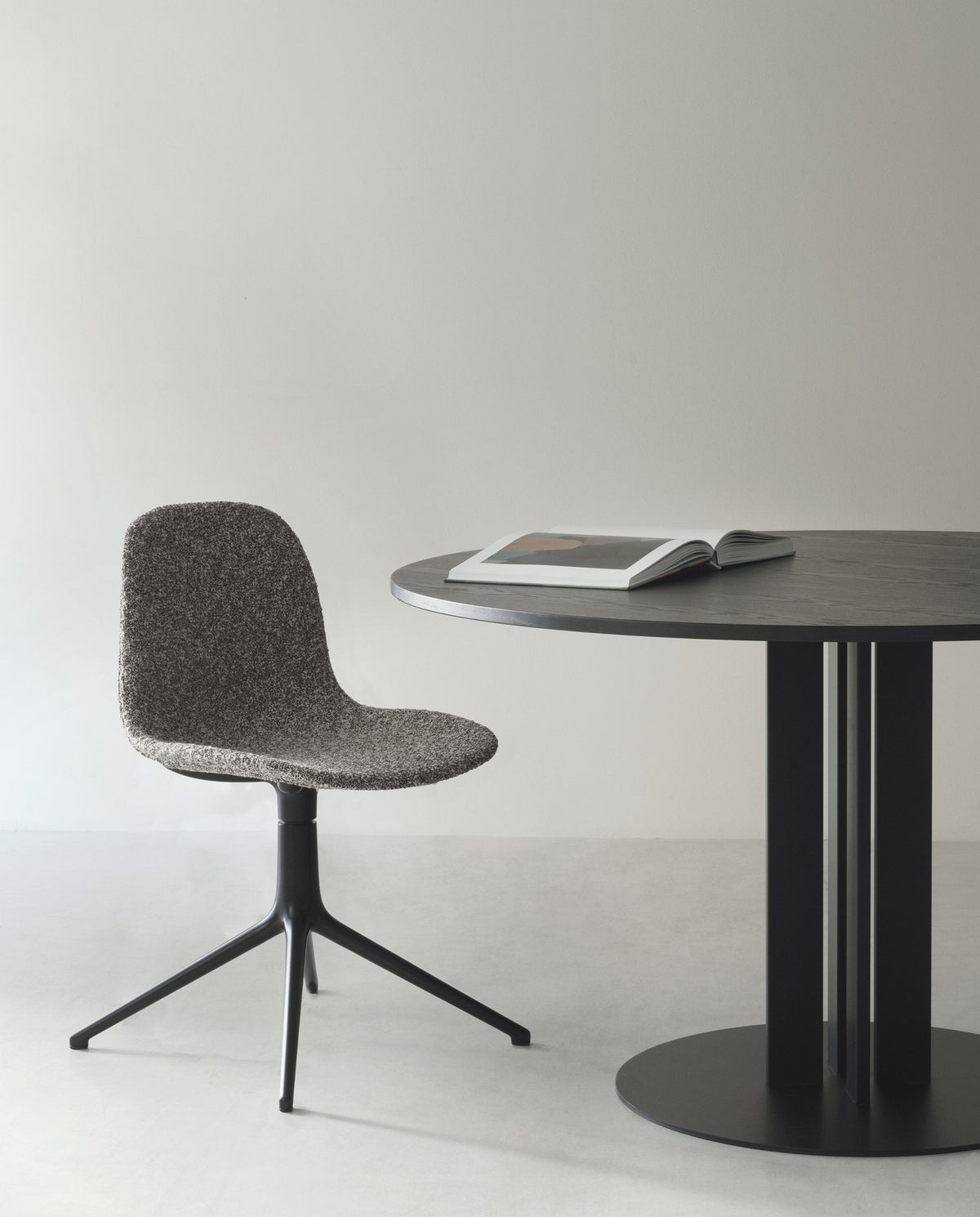 Runder Esstisch Scala von Normann Copenhagen mit Tischplatte in Eiche und schwarzem Stahlgestell aus vier Säulen, Durchmesser 150 cm.