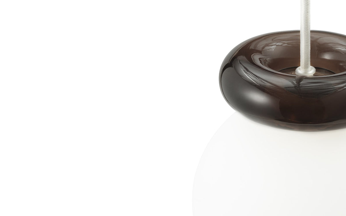 Pendelleuchte Hinx von Normann Copenhagen in Dunkelbraun, Lampenschirm aus Opalglas mit ringförmigem Kunstharzsockel.
