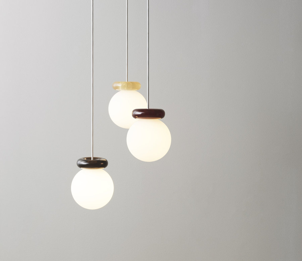 Pendelleuchte Hinx von Normann Copenhagen in Dunkelbraun, Lampenschirm aus Opalglas mit ringförmigem Kunstharzsockel.