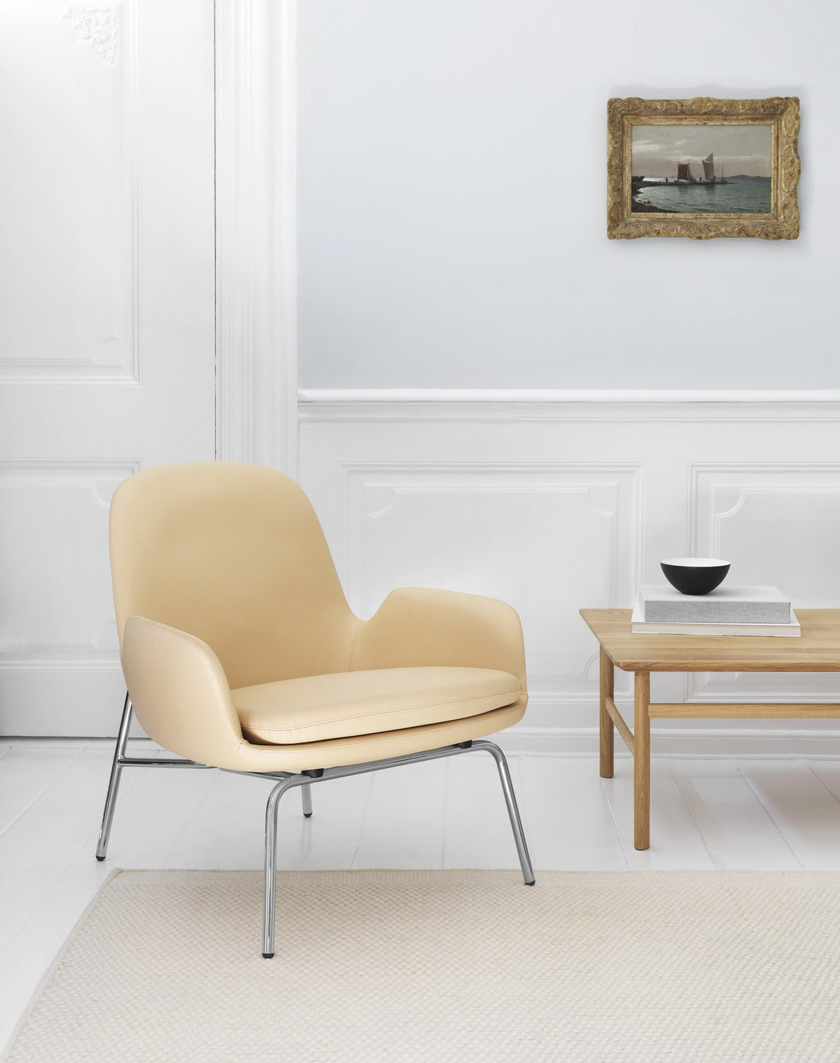 Era Lounge-Sessel von Normann Copenhagen in Beige mit gepolsterter Sitzschale, geschwungener Rückenlehne und schwarzem Stahlgestell.