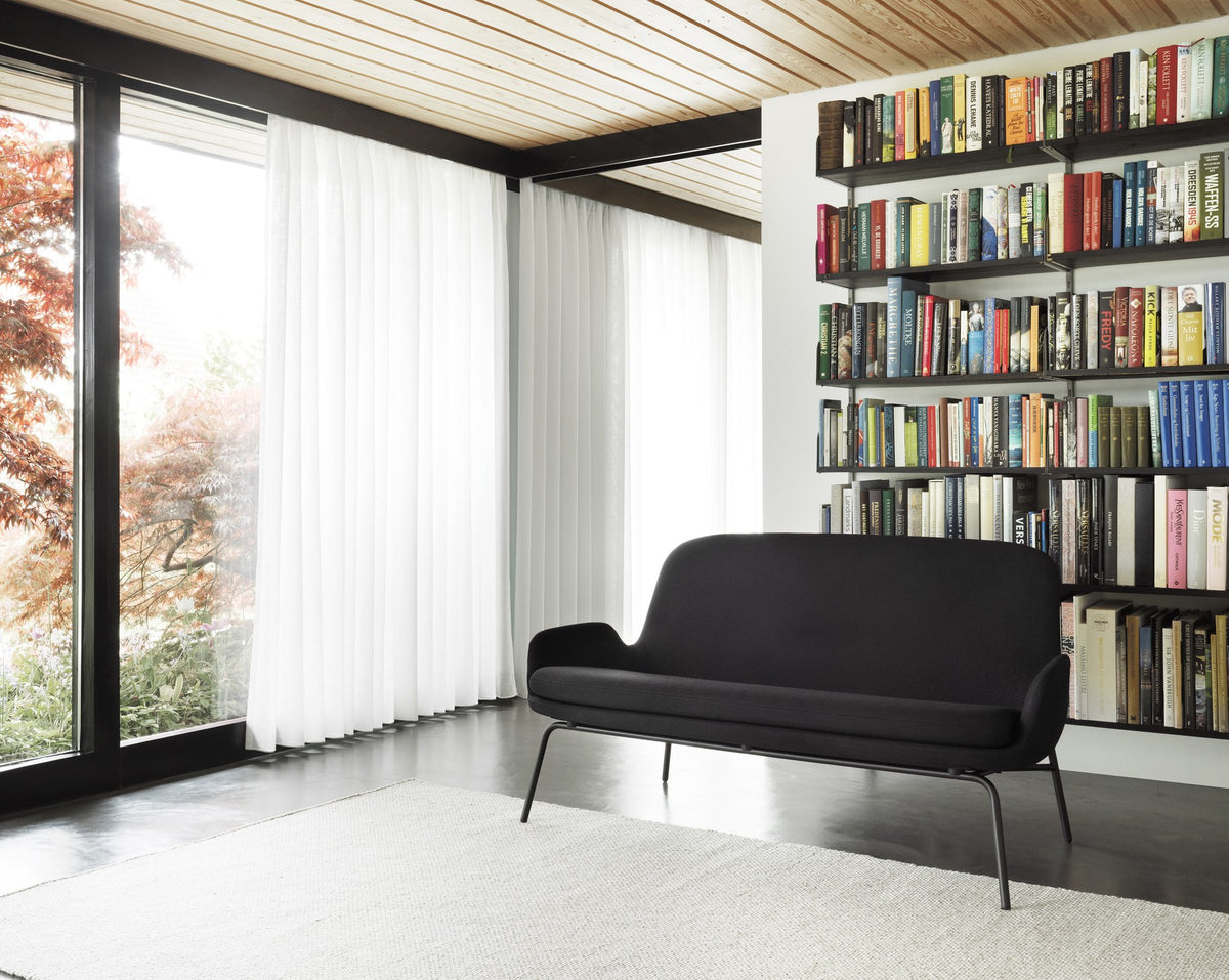 Era 2er Sofa von Normann Copenhagen in Schwarz mit gepolsterter Sitzschale und schwarzem Stahlgestell auf schlanken Beinen.