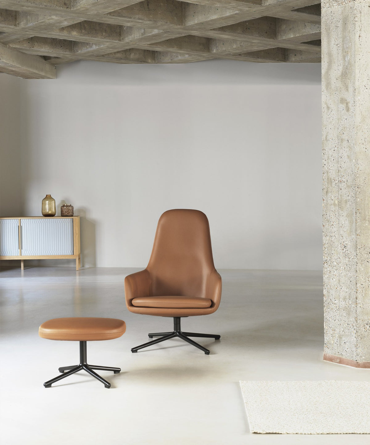 Era Fusshocker von Normann Copenhagen in Cognac, gepolstert mit gerundeter Form und verchromten Beinen.