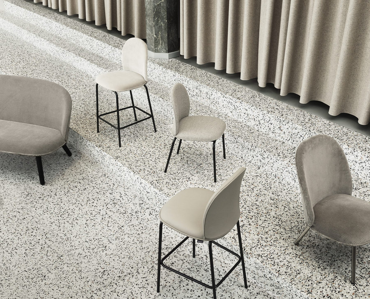 Ace Barstuhl von Normann Copenhagen mit gepolsterter Sitzschale aus Furnier und PU-Schaum, schwarzem Stahlgestell und schräg gestellten Beinen.