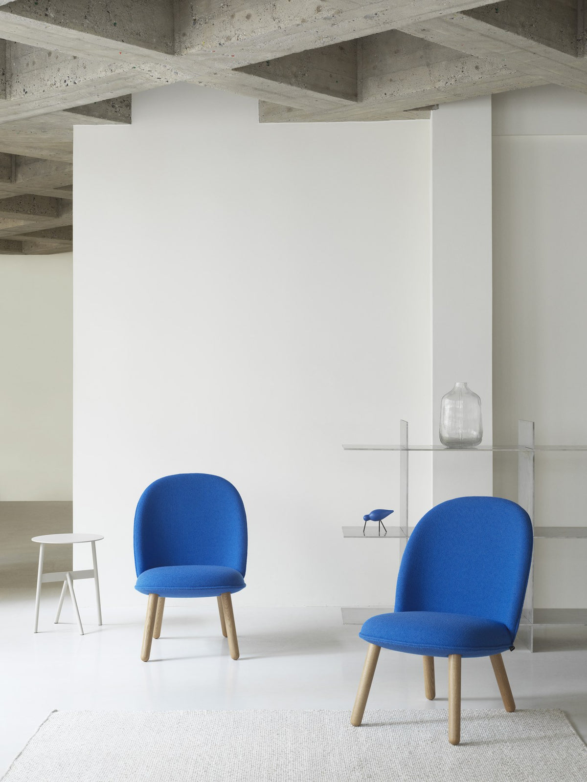 Ace Lounge-Sessel von Normann Copenhagen in Grau, gepolsterte Sitzschale mit Piping, schräg gestellte Beine aus Stahl.