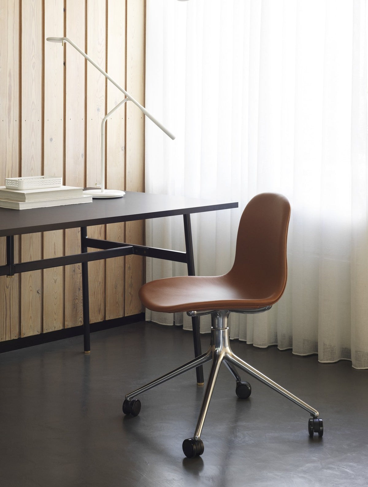 Form Drehstuhl von Normann Copenhagen mit gepolsterter Sitzschale in Braun und Drehgestell aus Aluminium mit vier Beinen.