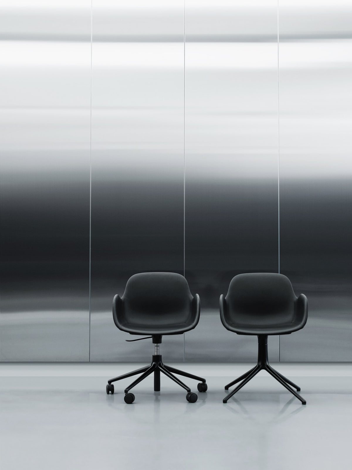 Schwarzer Form Drehstuhl von Normann Copenhagen mit gepolsterter Sitzschale aus Polypropylen, Aluminiumfuss und fünf Rollen.