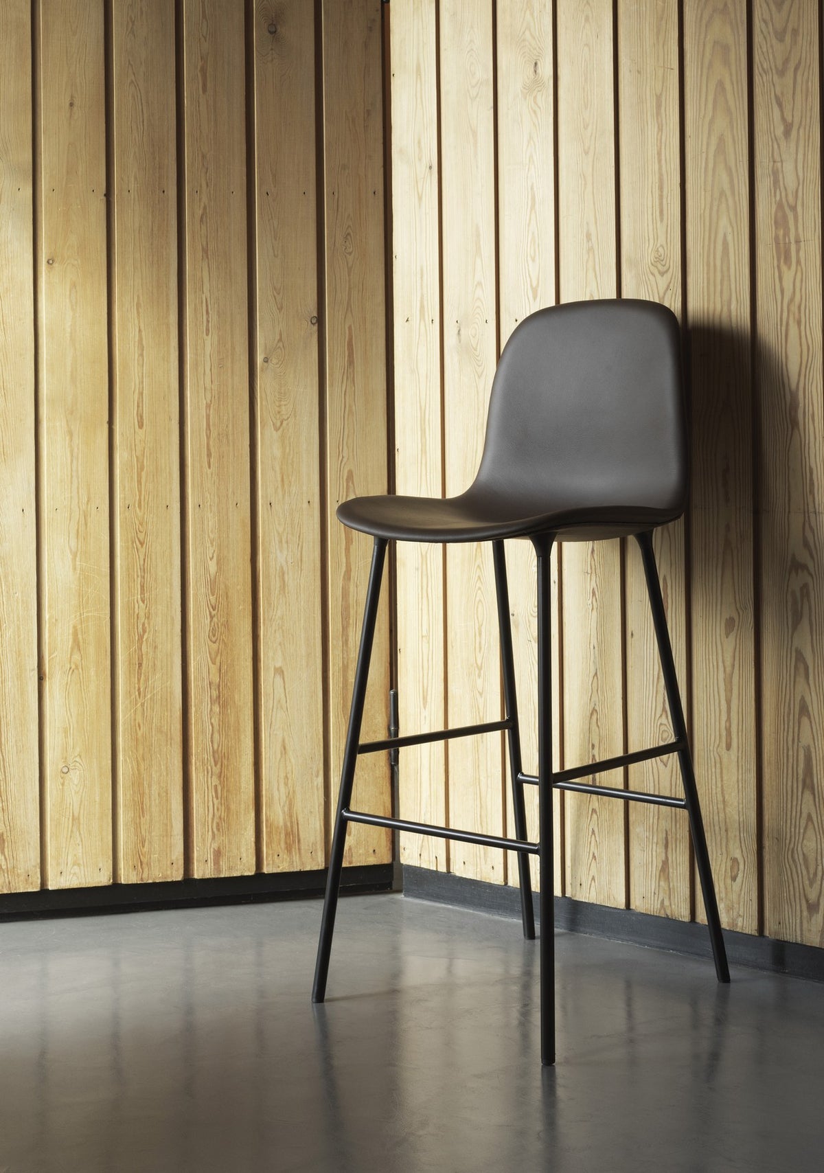 Grauer Barstuhl Form von Normann Copenhagen mit gepolsterter Sitzschale, Stahlbeinen und Sitzhöhe 65 cm.