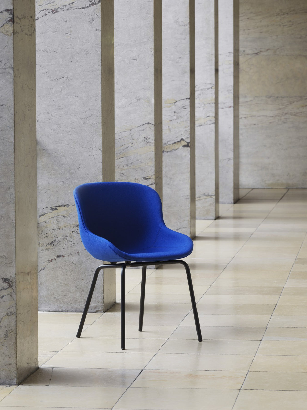 Blauer Polsterstuhl Hyg Chair Full Upholstery von Normann Copenhagen mit organisch geformter Sitzschale und Gestell aus Stahl.