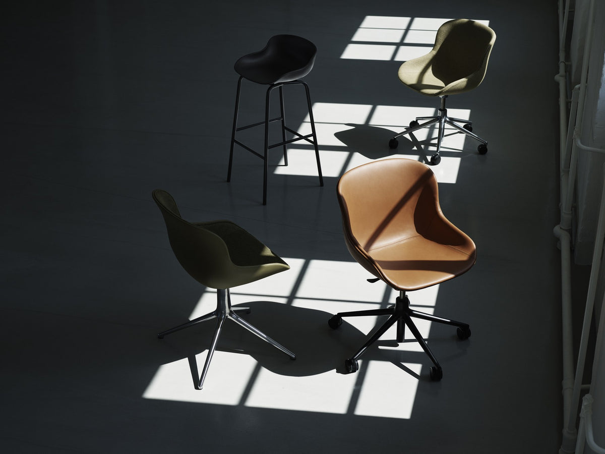 Hyg Drehsessel mit Rollen und Frontpolster von Normann Copenhagen in Anthrazit, Schale aus Polypropylen, Gestell aus Stahl.
