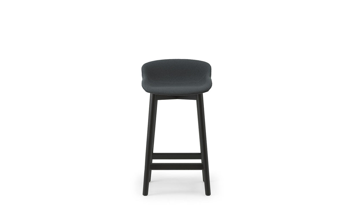 Hyg Barhocker von Normann Copenhagen mit vollständig gepolsterter Sitzschale aus Polypropylen, Gewebebezug UDA25 und lackierten Beinen aus Eiche, Sitzhöhe 65 cm.