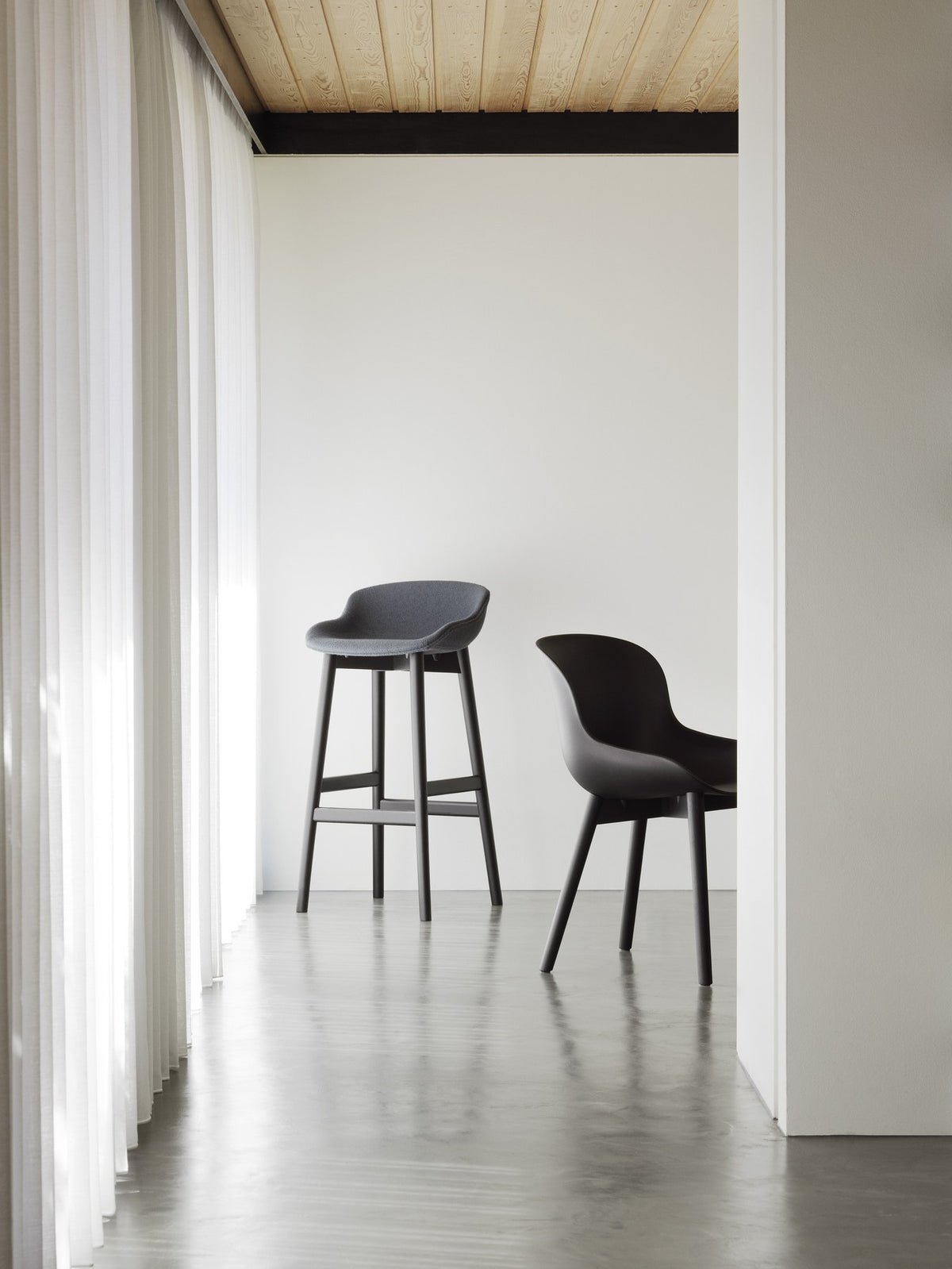 Hyg Barhocker von Normann Copenhagen mit sandfarbener Frontpolsterung, Schale aus Polypropylen und Gestell aus Eichenholz, Sitzhöhe 75 cm.