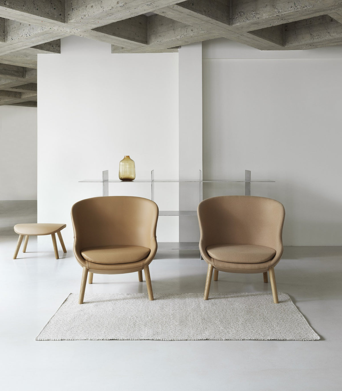 Hyg Fusshocker von Normann Copenhagen, Ottoman mit rundlicher Form aus geformtem PU-Schaum, Bezug grau, Beine schwarze Eiche.