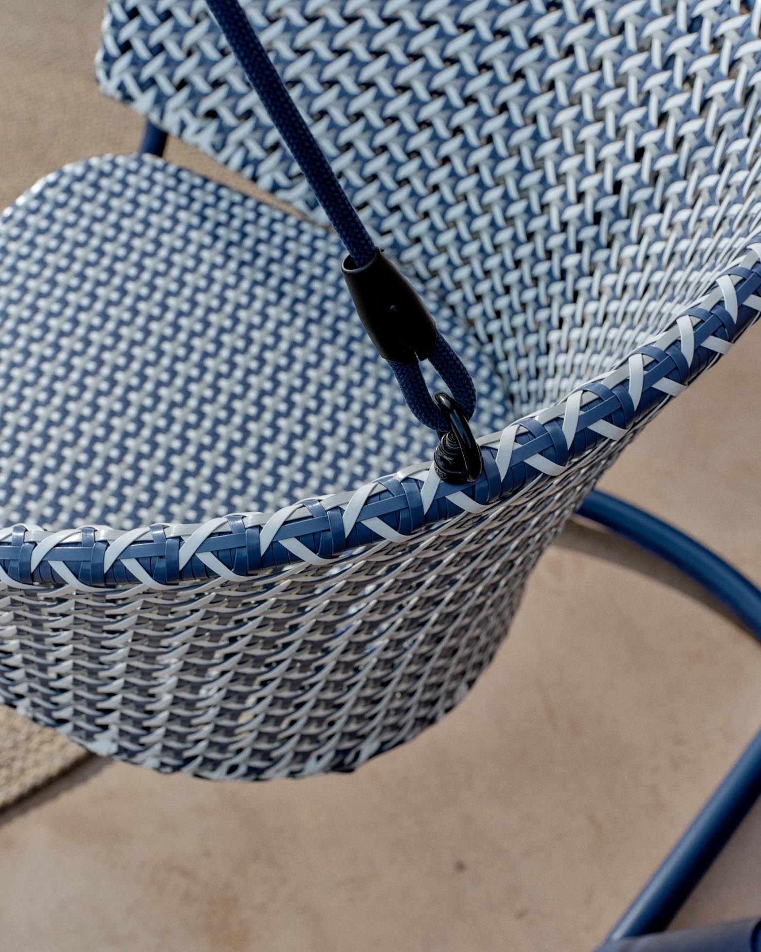 Eleganter Hängesessel aus Aluminium und blauem Rattan, robust, pflegeleicht, mit Fußteil für maximalen Komfort.