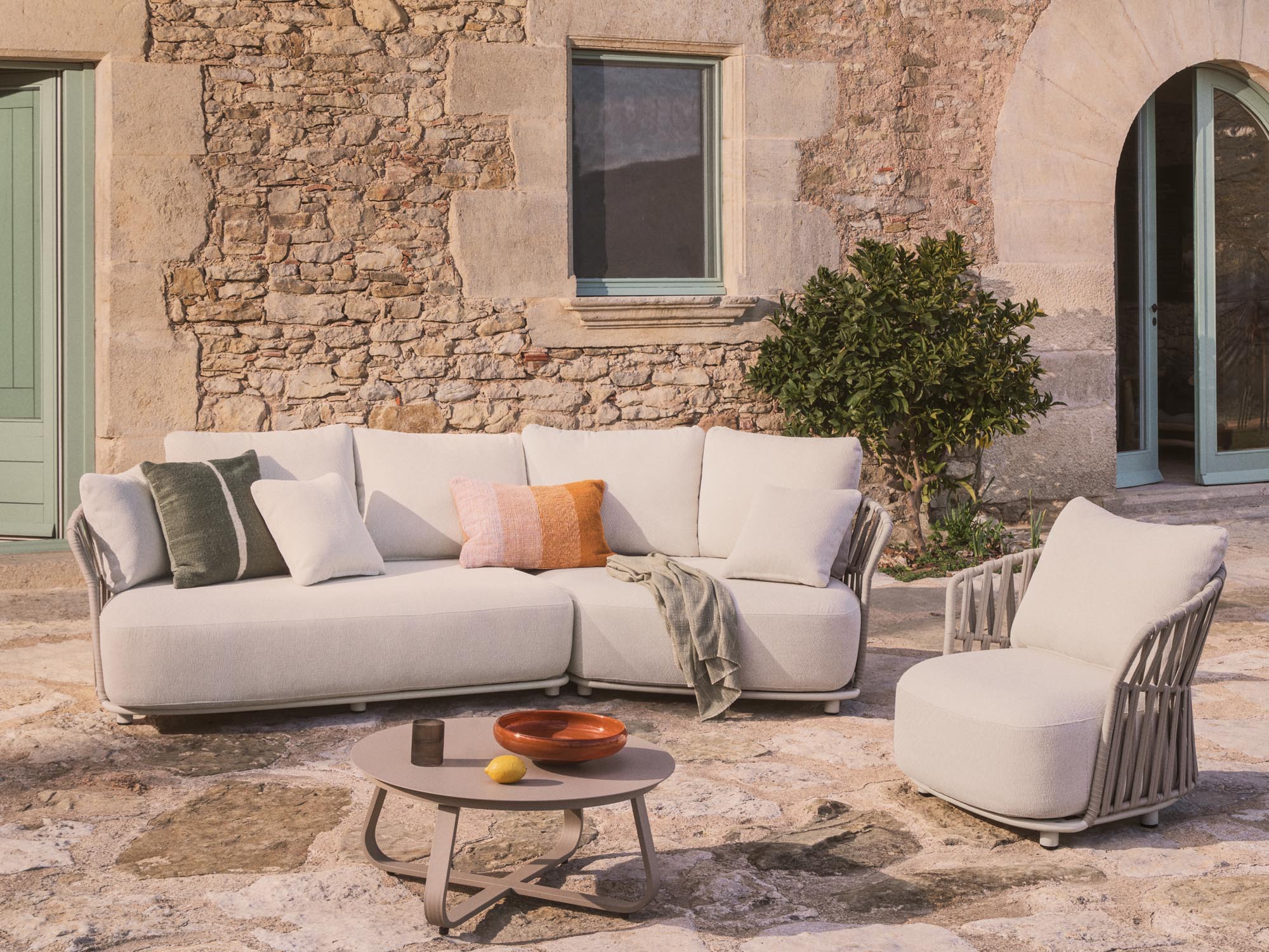 Stylisches Lounge Sofa Osani in geschwungenem Design, aus ecrufarbenem Aluminium und taupefarbenem Seil, perfekt für entspannte Stunden im Freien.