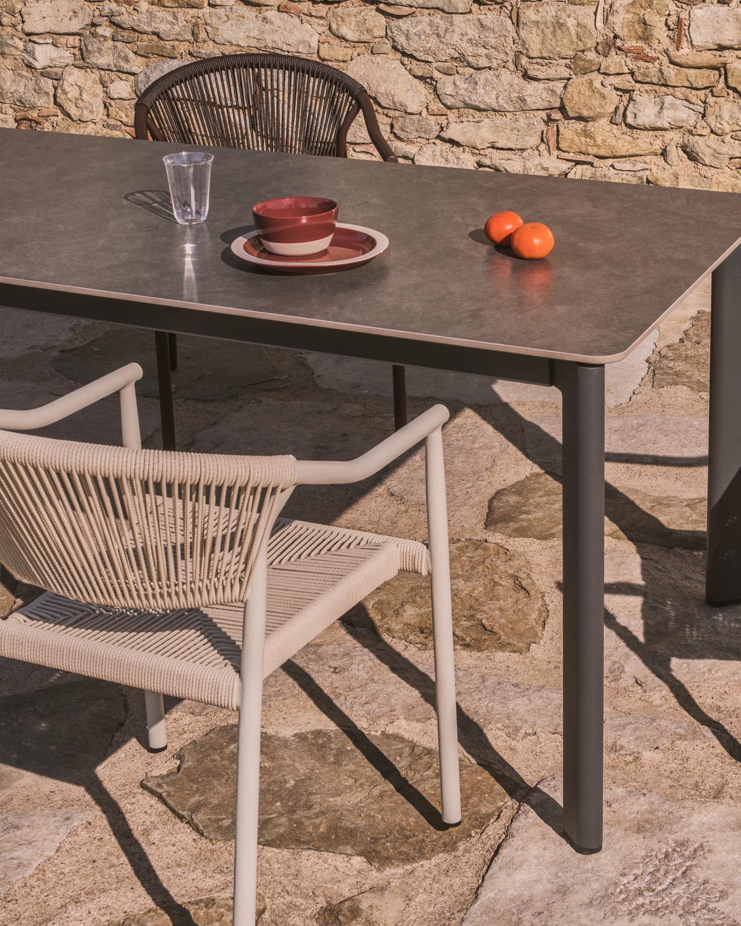 Tischset Anafi aus gesintertem Stein und graphitgrauem Aluminium sowie 4 Stühle Livadia aus graphitgrauem Aluminium, 180 x 90 cm in Graphit präsentiert im Onlineshop von KAQTU Design AG. Loungeset ist von Kave Home