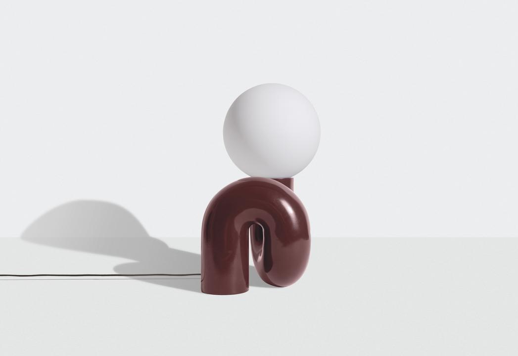Grosse Tischlampe Neotenic von Petite Friture mit glänzend kirschrot glasiertem Keramiksockel und sandgestrahltem weissem Glasglobus in geschwungener Form.