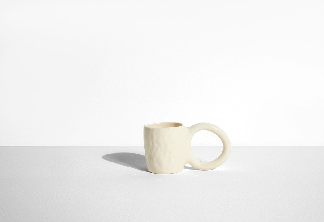 Keramiktasse Donut in Pistazie mit glasierter Oberfläche und donutförmigem Henkel, mittlere Grösse, handwerklicher Look, auf hellem Hintergrund.