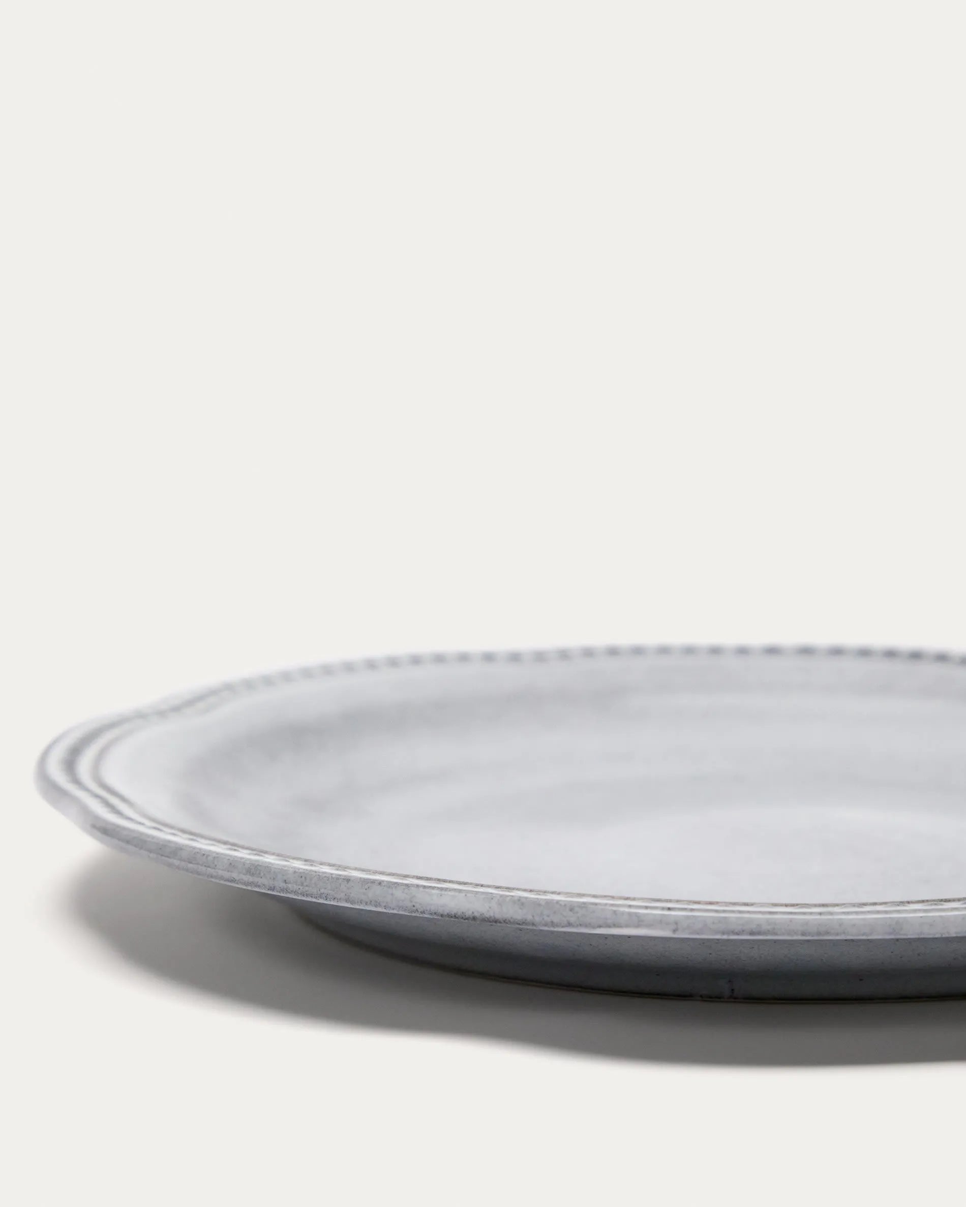 Eleganter blauer Keramikteller von Kave Home, robust, kratzfest, ideal für stilvolle Präsentationen.