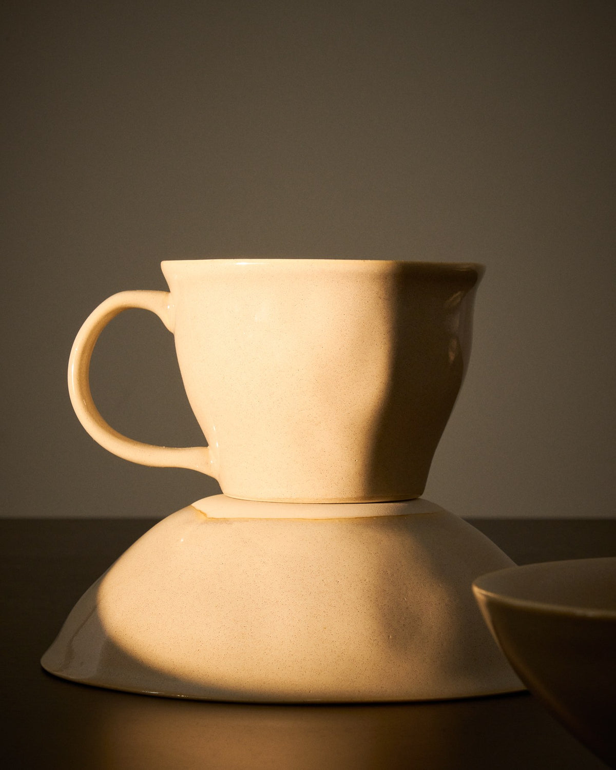 Elfenbeinfarbene Tasse aus Keramik mit glänzender Oberfläche, schlichter Form, Teil der Aderno-Kollektion von Kave Home.