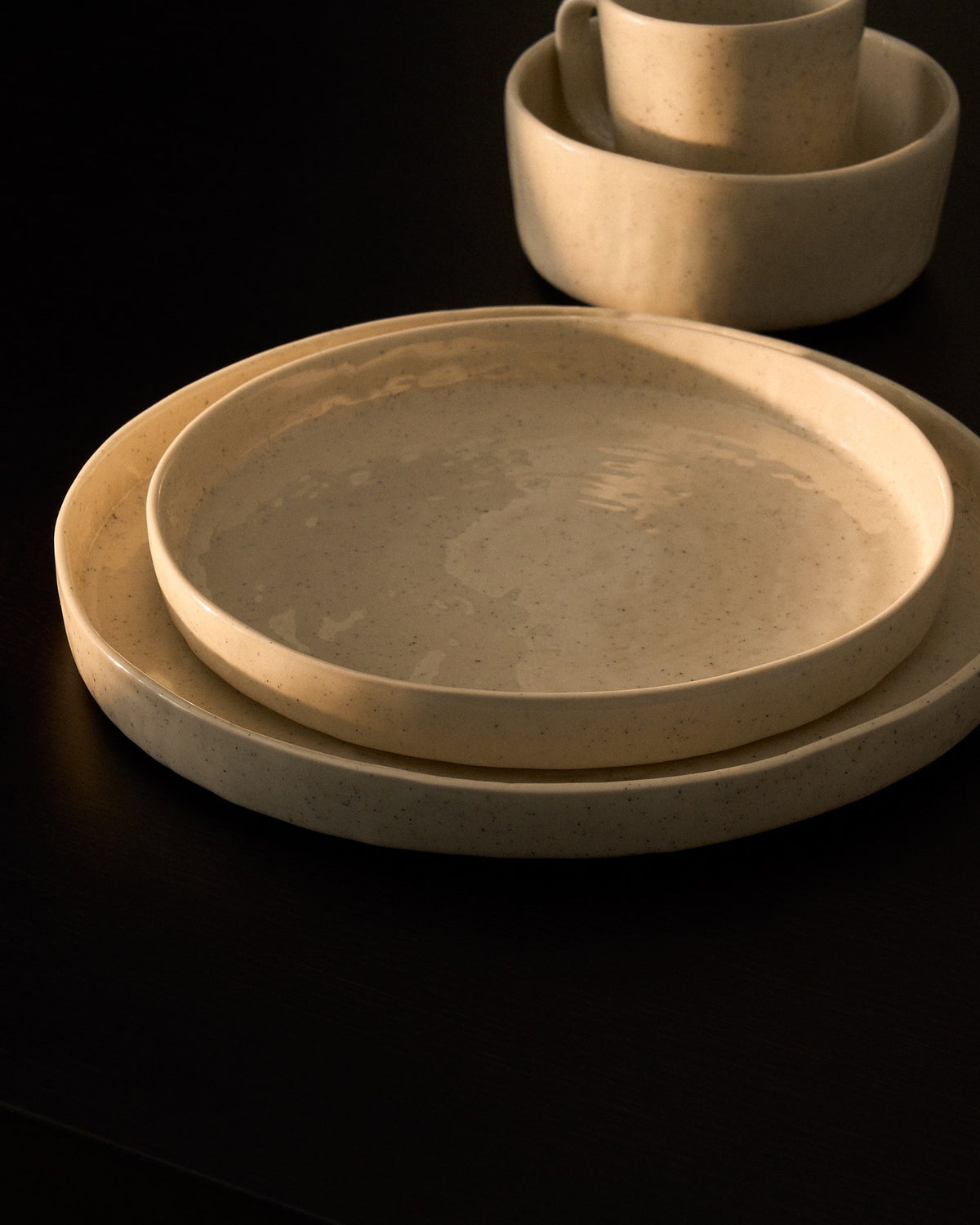 Flacher Teller aus Keramik in den Farben Weiss und Beige (Écru), runde Form mit reaktiver Glasur, Durchmesser 27.5 cm.