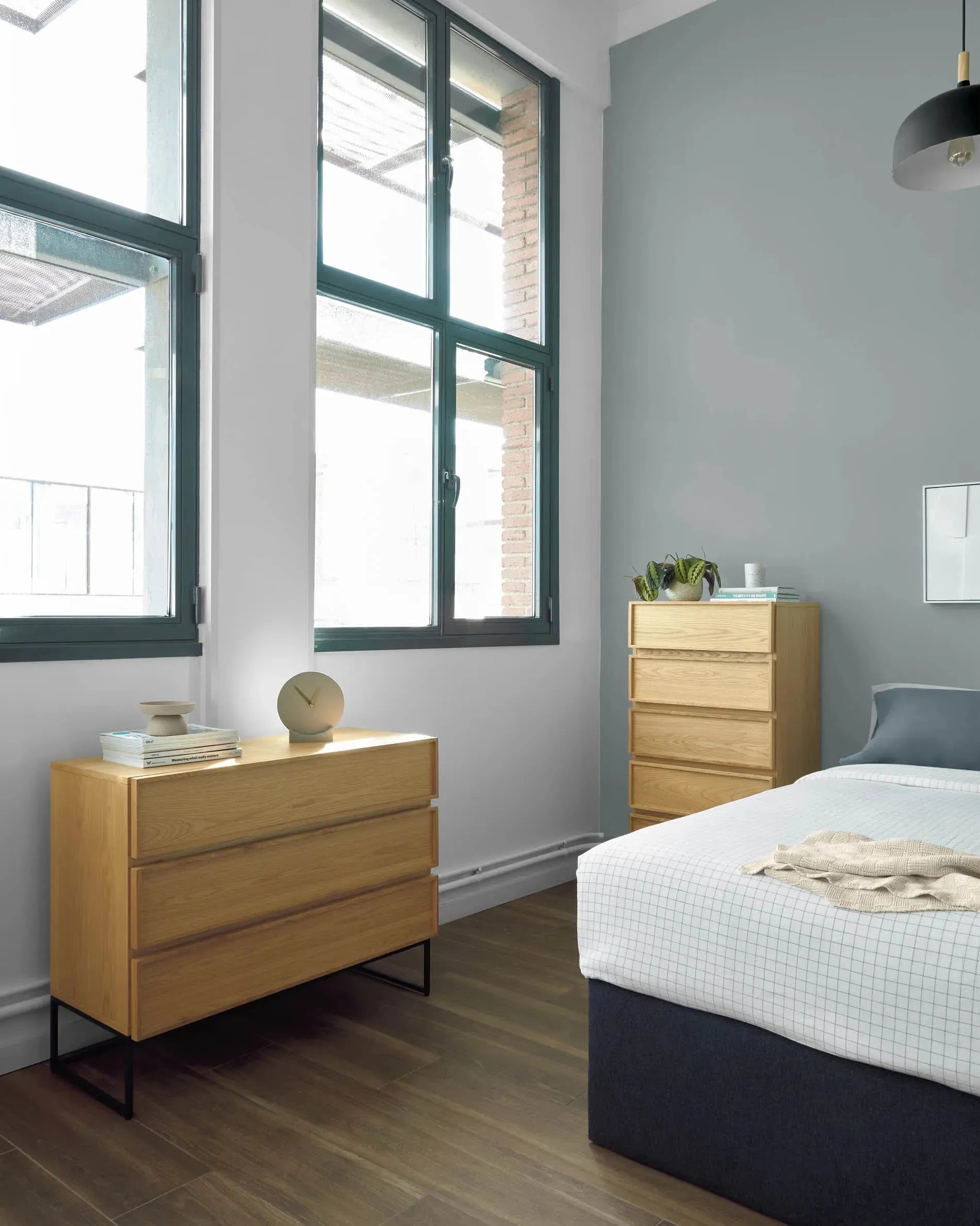 Die Taiana Kommode kombiniert Eichenfurnier und schwarzen Stahl in modernem Design, mit 3 Schubladen und Maßen von 100 x 78 cm.