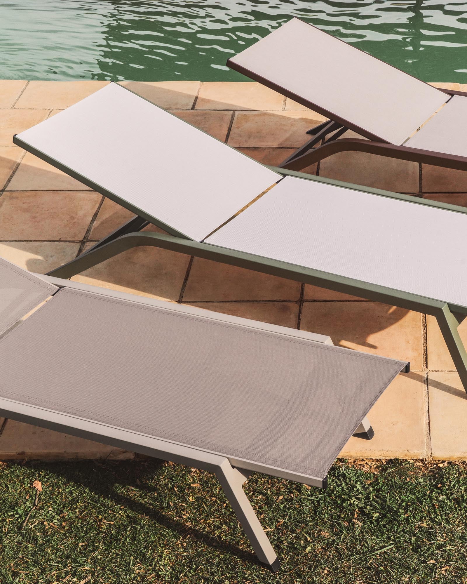 Elegante stapelbare Sonnenliege Capraia aus robustem braunem Aluminium und hellem Texteline, ideal für entspannte Stunden im Freien.