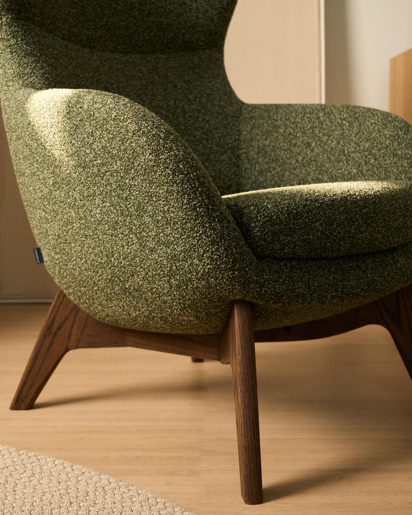 Sessel Adiran mit dicker Chenille in Moosgrün und Beinen aus massivem Eichenholz mit Nussbaum-Finish in Dunkelgrün präsentiert im Onlineshop von KAQTU Design AG. Sessel ist von Kave Home