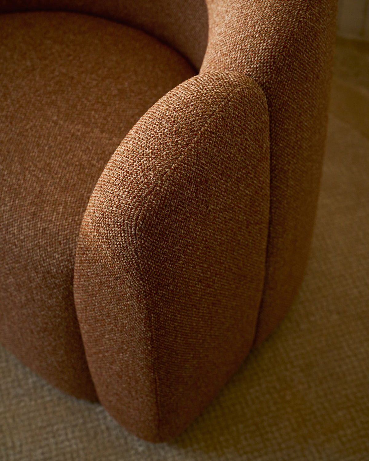 Sessel Corvena mit Chenille-Bezug in Terrakotta, runde Formen, integrierte Armlehnen und Kunststoffgleiter, Holzgestell aus Pappelsperrholz.
