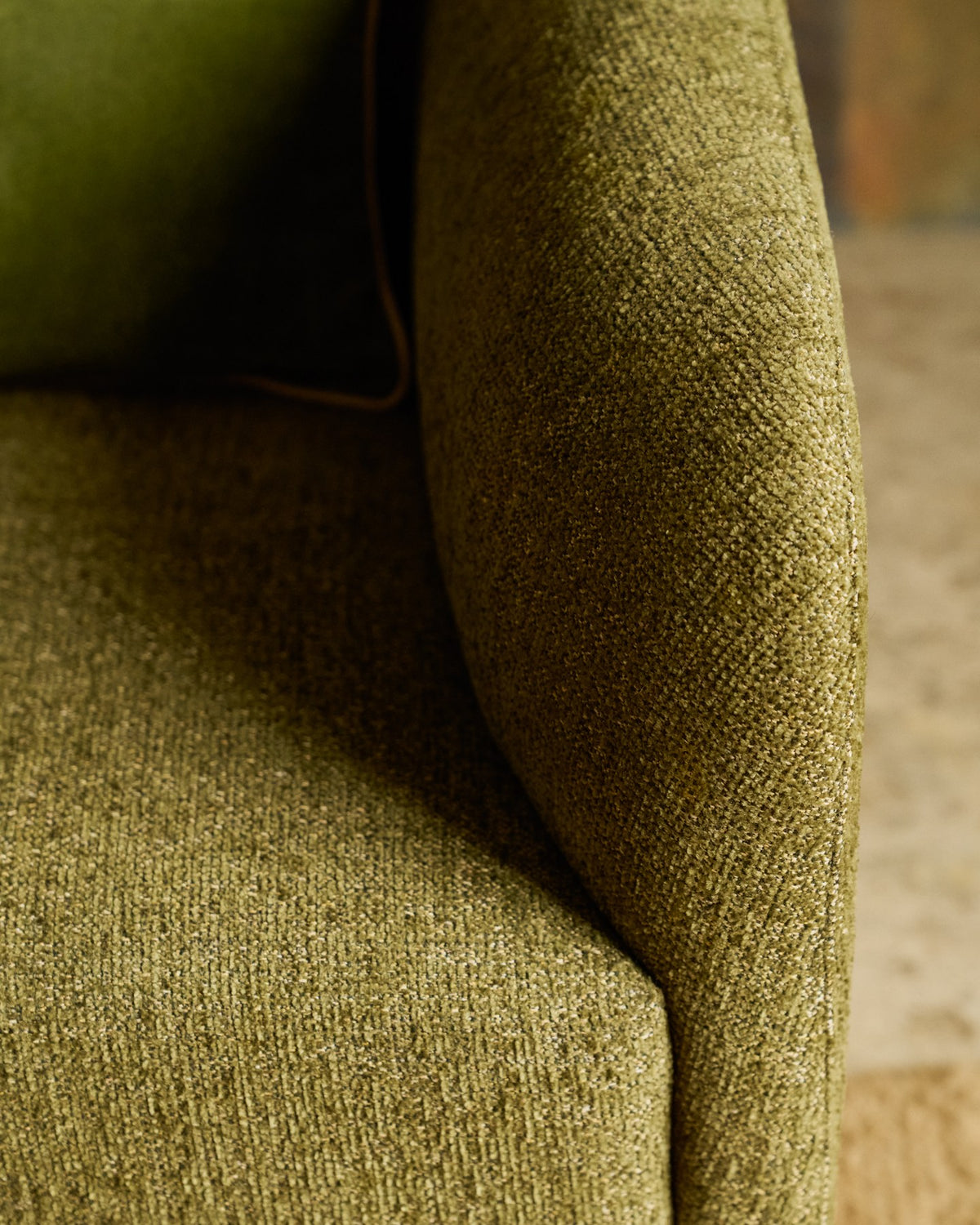 Olivgrüner Sessel Milare mit Chenille-Bezug, schwarzen Kunststoffgleitern und geschwungener Rückenlehne, Sitzbreite 53 cm.