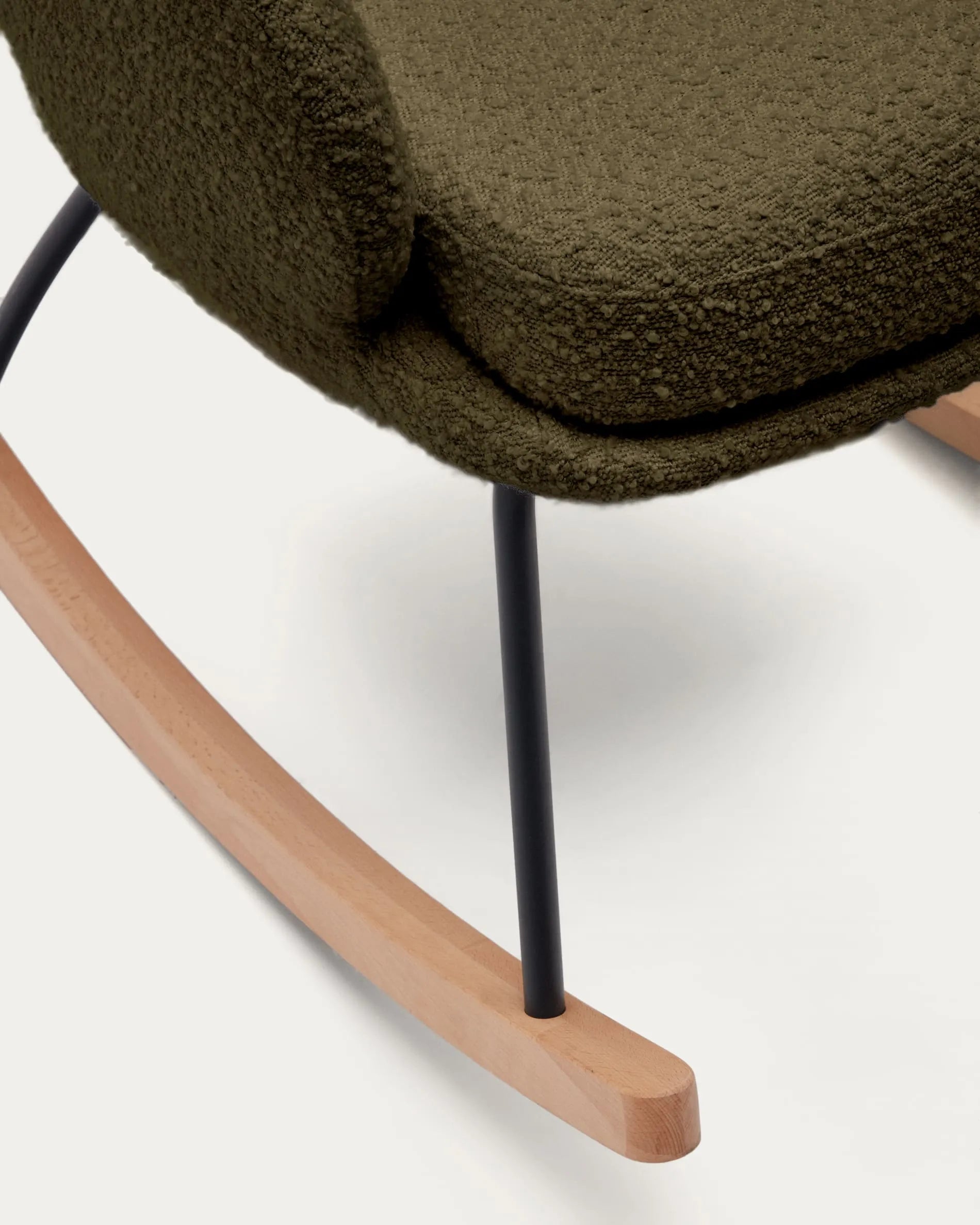 Eleganter Schaukelstuhl mit dunkelgrünem Bouclé, Stahl- und Buchenholzgestell, ideal für stilvolle Entspannung.