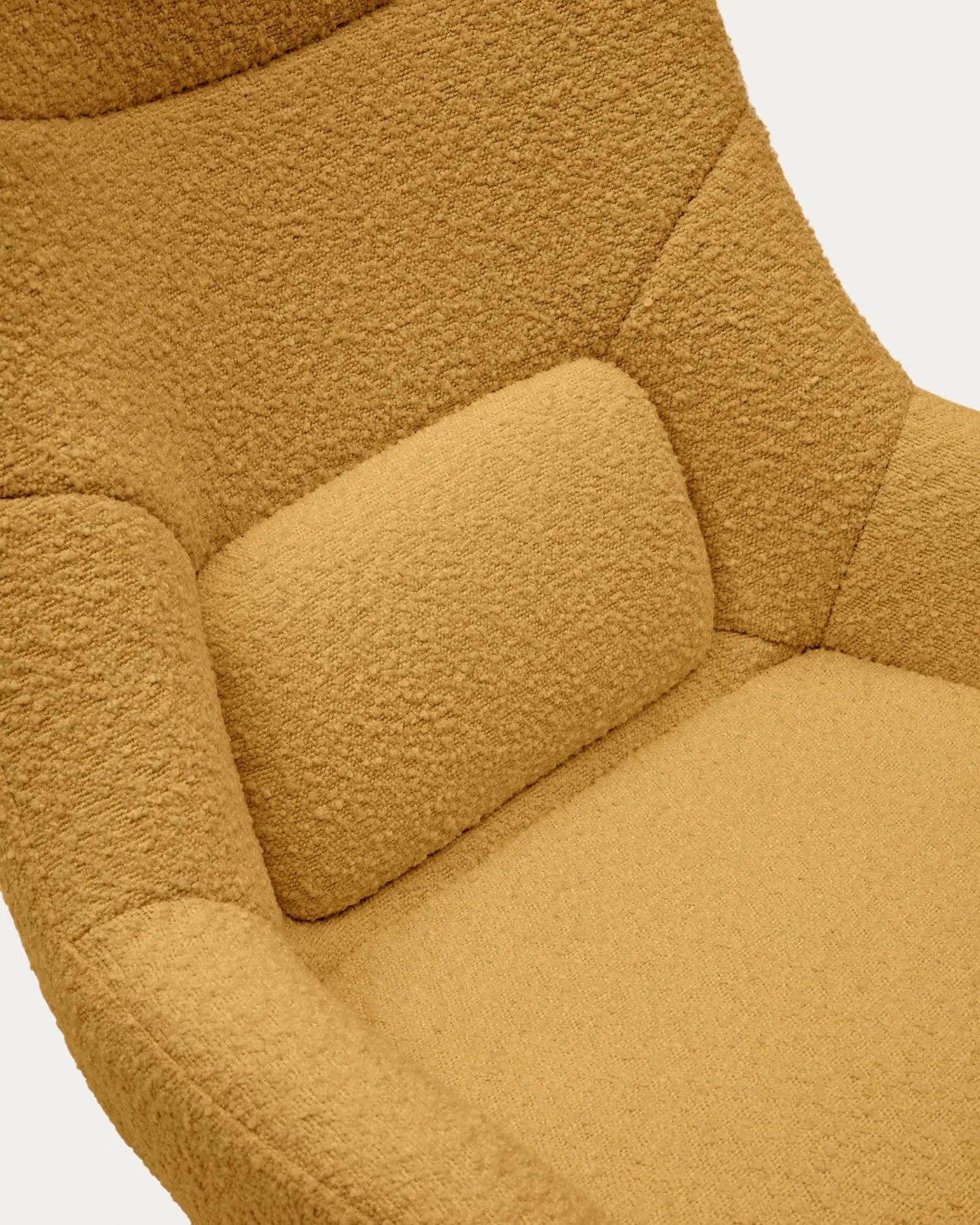 Der Celida Drehsessel vereint senffarbenes Bouclé mit schwarzem Stahl für stilvolle Eleganz und nachhaltigen Komfort.