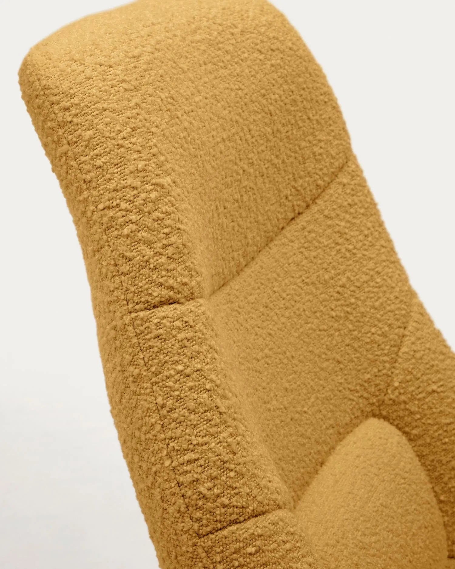 Der Celida Drehsessel vereint senffarbenes Bouclé mit schwarzem Stahl für stilvolle Eleganz und nachhaltigen Komfort.